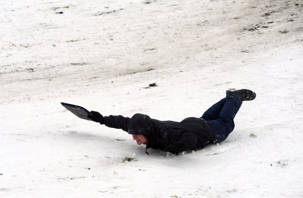 Belly sledding in a black suit, big hill, record snow day, Gas Works Park, Wallingford, Seattle, Washington, USA by Wonderlane