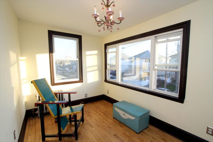 Bright indoor living room and visible houses outside.
