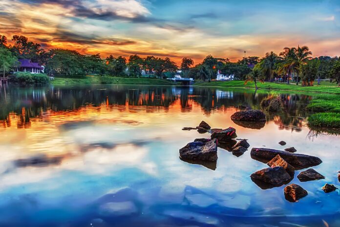 HDR image of lake and trees in vibrant blue, grean and orange