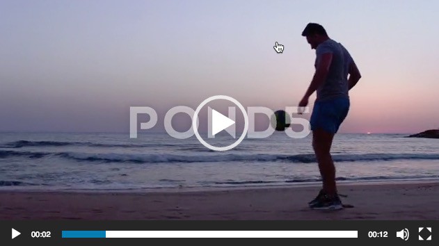 Man Juggling Soccer Ball Close Up on Seashore at Sunset