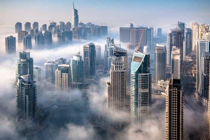 An impressive aerial top view of the Dubai Skyline on a foggy day.