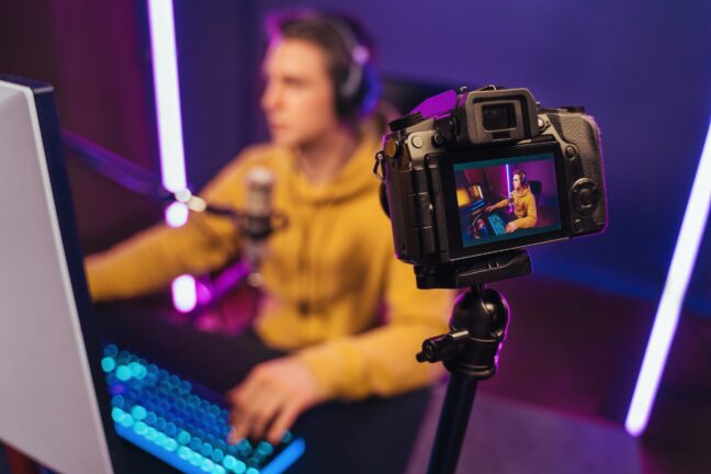 Gamer sitting on a desk with a camera in front