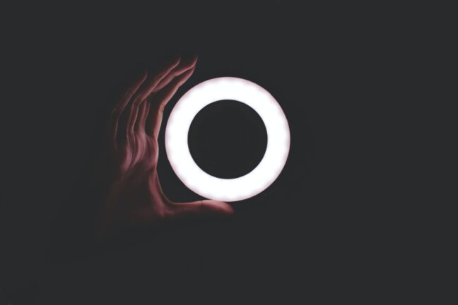 Hand with ring light surrounded by darkness