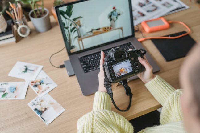 Person looking at back of camera while sitting at computer