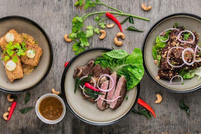 Food dishes including beef, cashews, peppers, and onions from a top-down perspective.