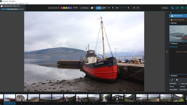 A photo of a red boat on the shore of a lake displayed in Excire Foto.