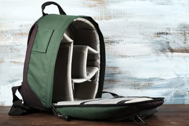 Budget camera backpack in green showing empty inside compartments. 