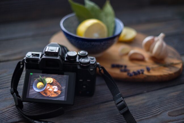 A camera showing a food photography arrangement on the LCD with the actual arrangement in the background.