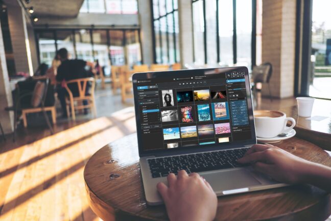 Person sitting in a cafe while using a laptop displaying Excire Foto 2024.