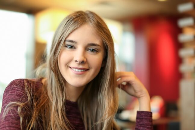 Portrait of beautiful smiling young woman in cafe.