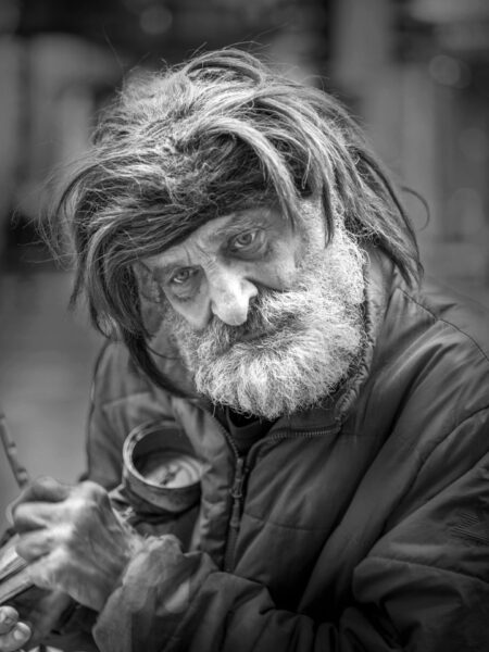 Homeless man in Chicago looking down and distant in black and white.