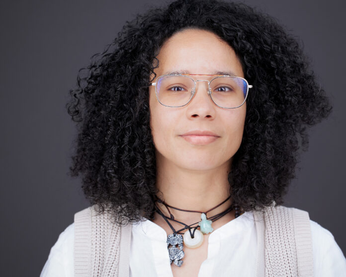 Professional headshot of woman with black hair and white shirt.