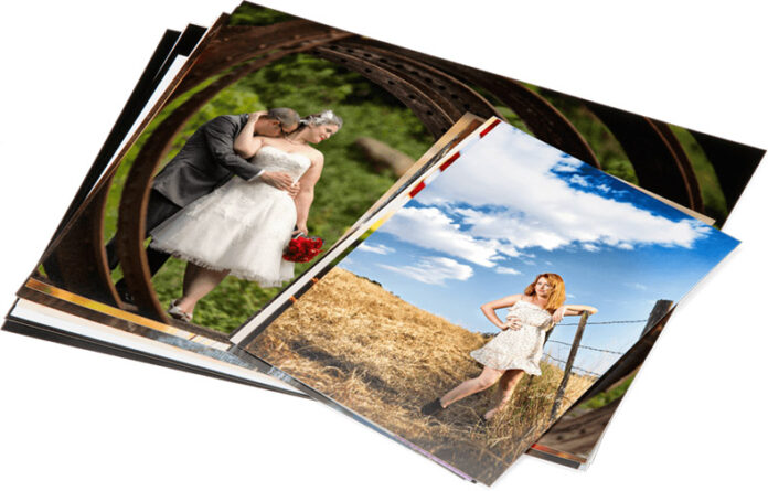 A pile of printed photographs by Bay Photo displaying various outdoor scenes including a couple in wedding attire and a woman posing in a field.